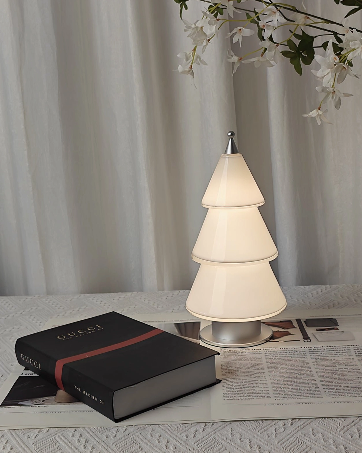 White acrylic tiered cone LED lamp with chrome metal base on contemporary minimalist workspace setting