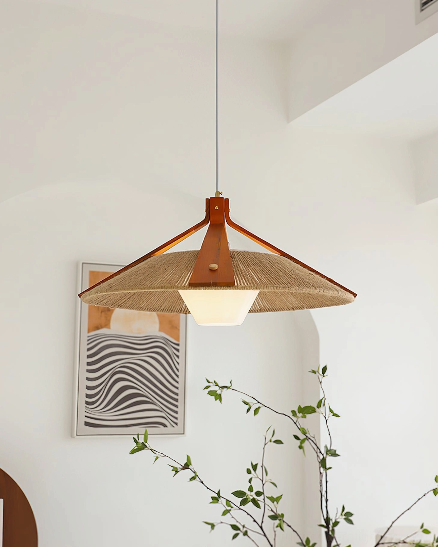 Direct front view of Millier pendant with conical woven shade and solid wood support frame in minimalist interior space