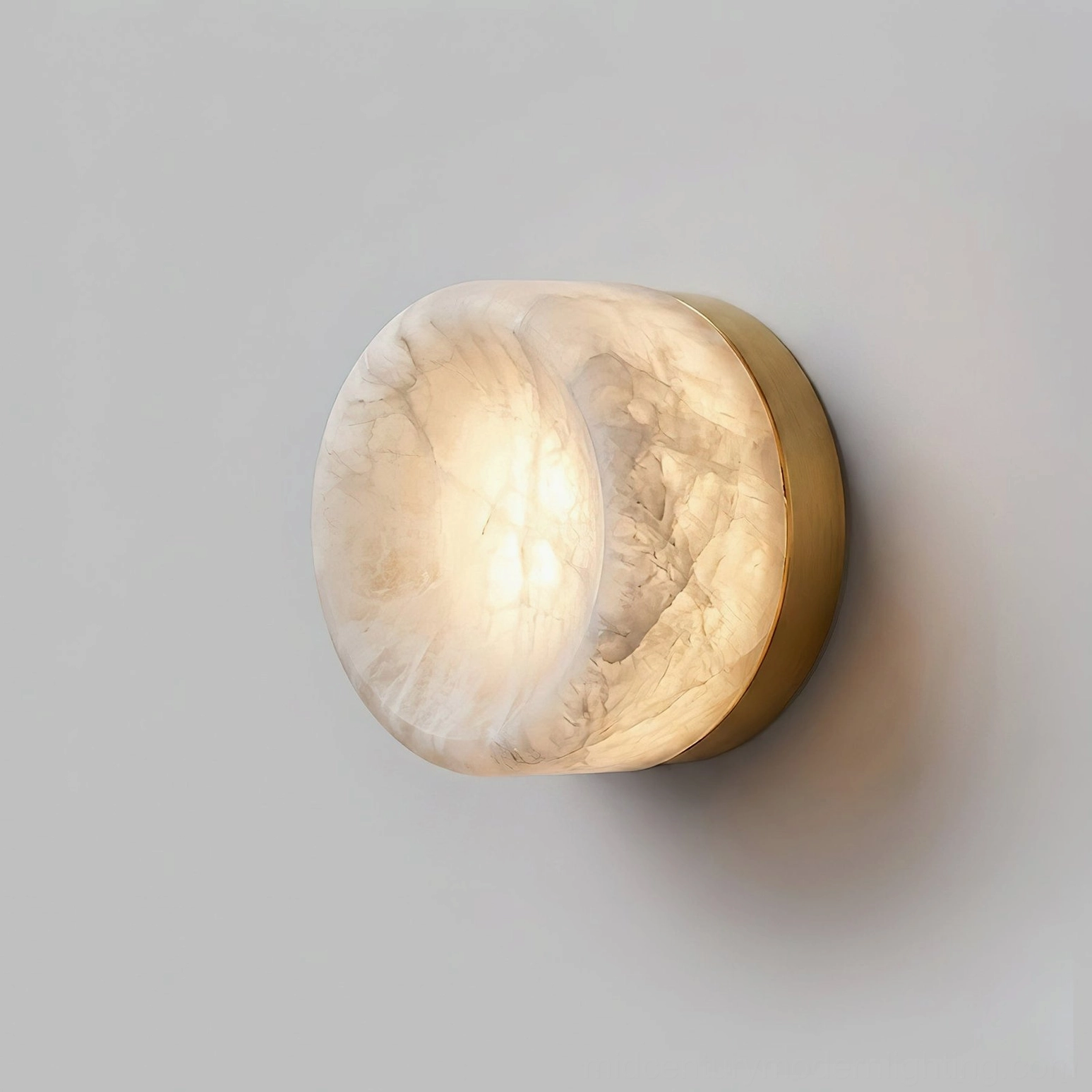 Warm glowing alabaster wall sconce integrated into contemporary interior design creating quiet luxury ambiance