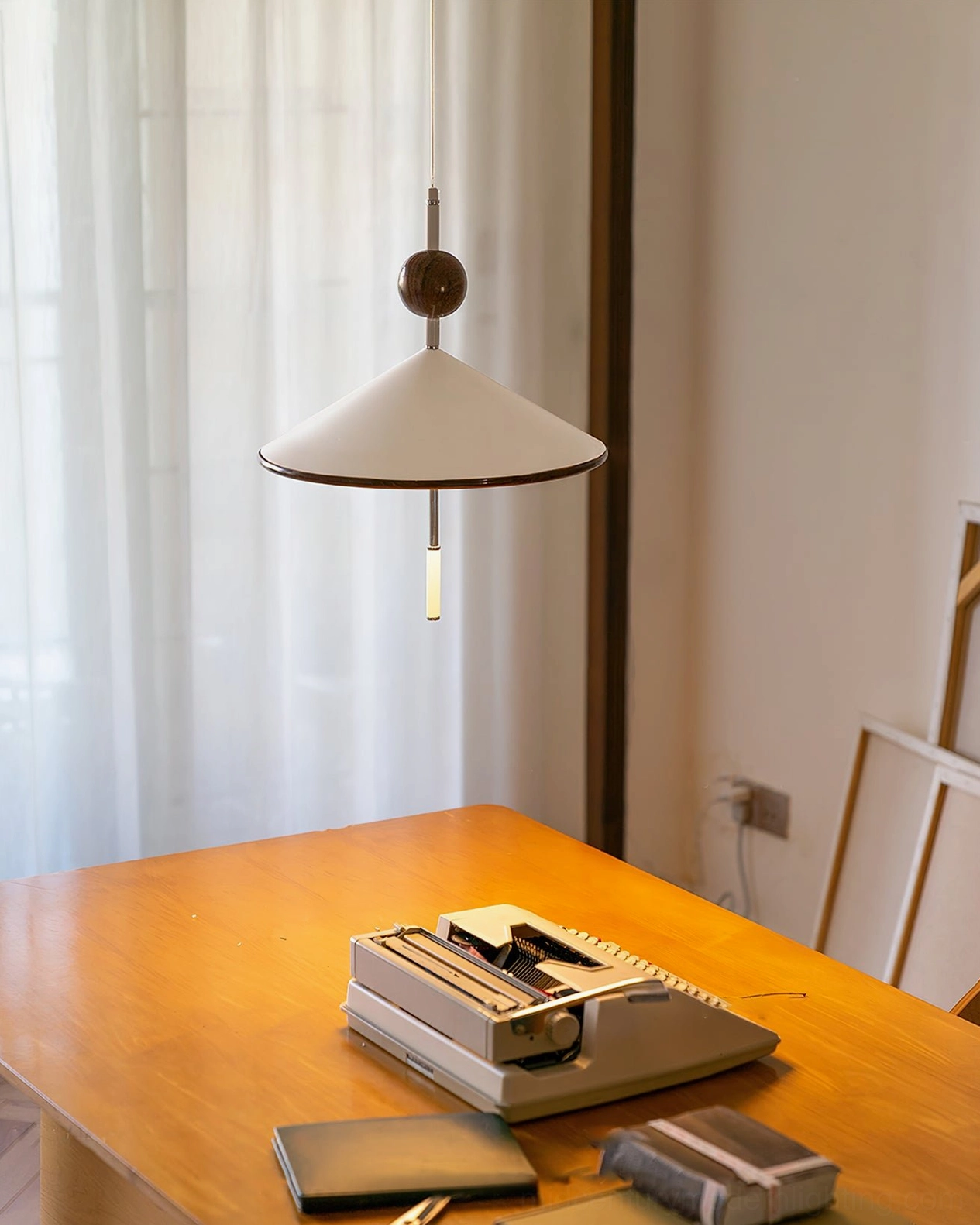 Contemporary alien pendant fixture suspended over wooden desk in creative workspace setting