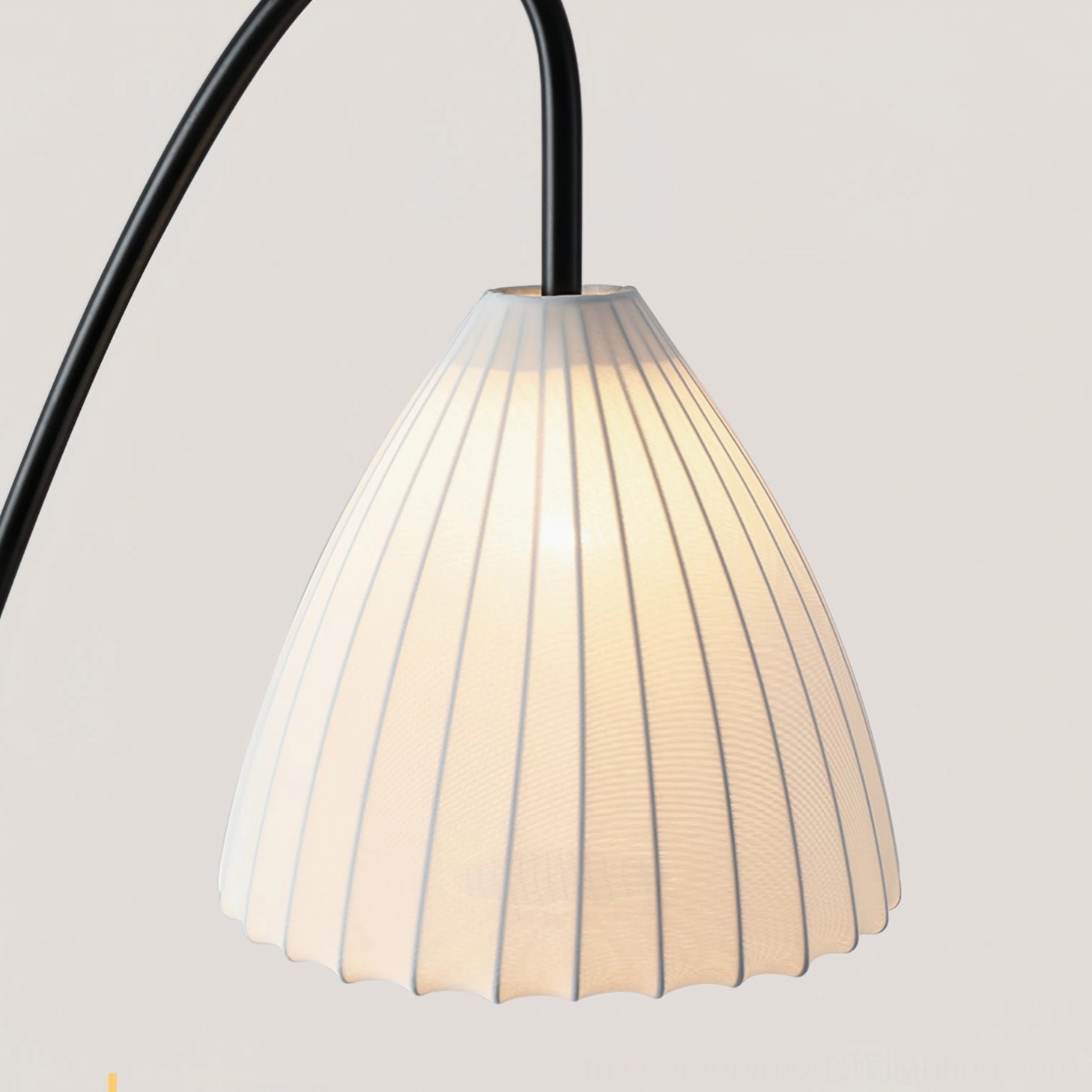 Contemporary arc tripod floor lamp showing curved arm mechanism and pleated fabric shade for diffused ambient lighting