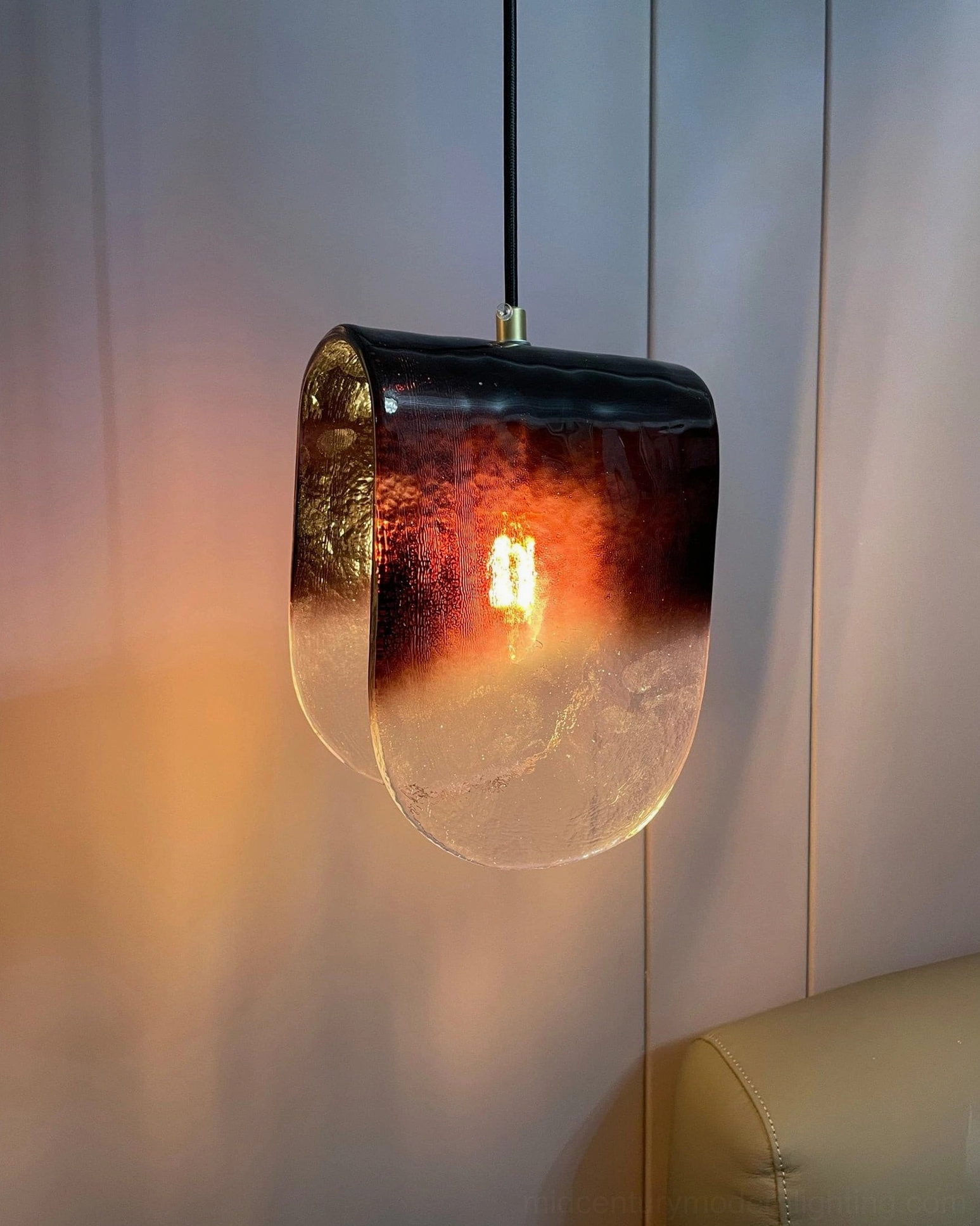 Contemporary ceiling pendant installation showing brass mount and geometric glass form