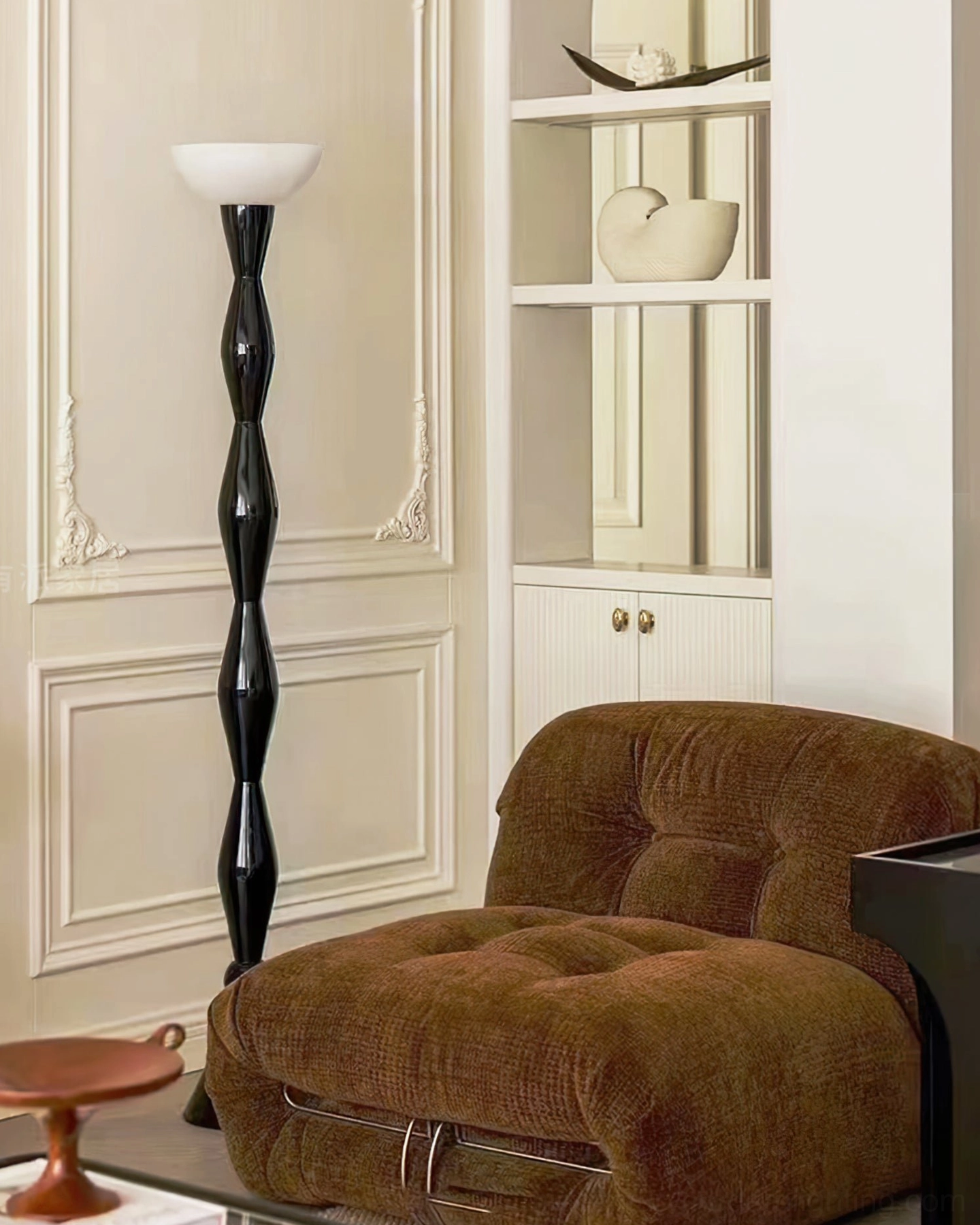 Modern twisted black floor lamp beside tufted armchair against paneled wall, traditional elegant minimalist style