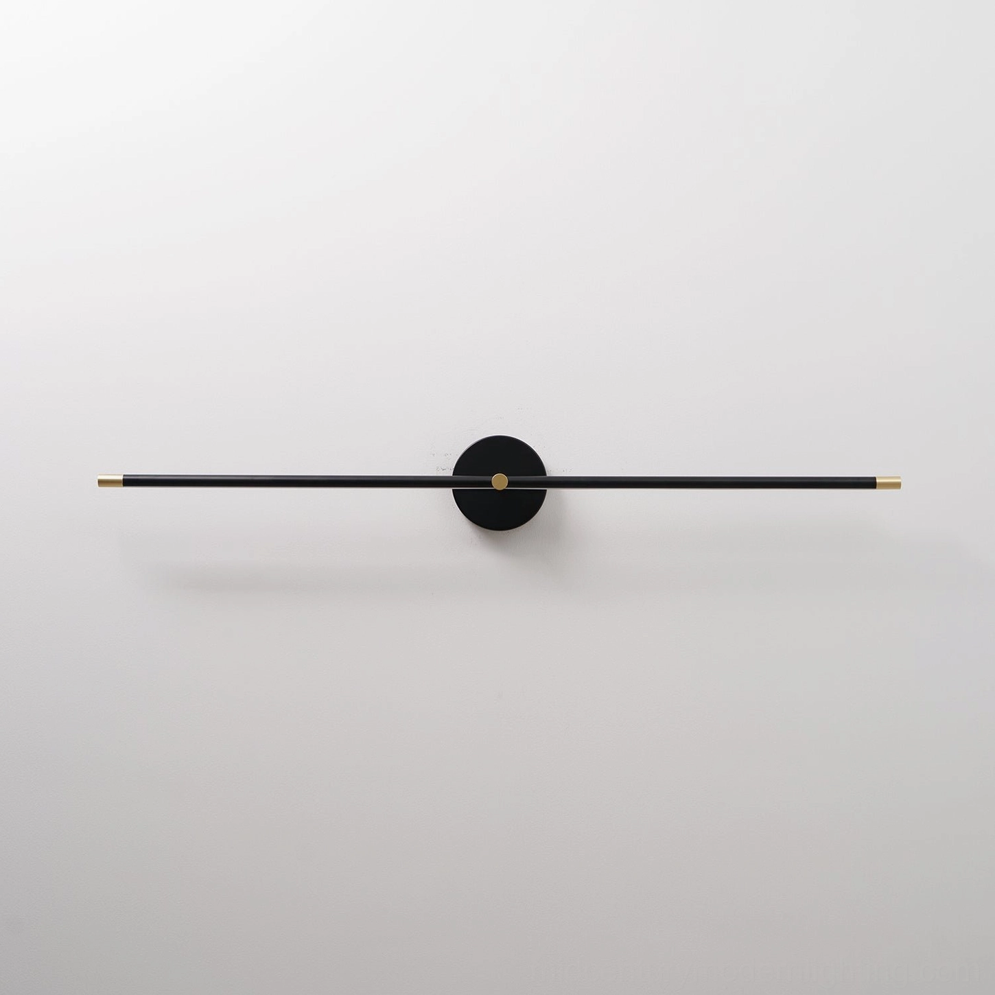 Contemporary linear wall lamp featuring slim rod and circular mount on white wall