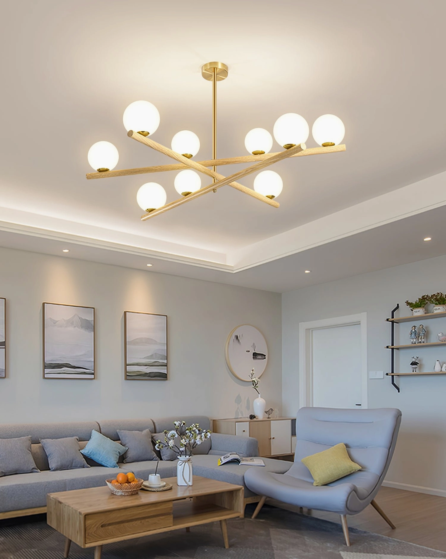 Minimalist living room interior featuring 9-globe sputnik chandelier with sectional seating, accent chair, and wall shelving
