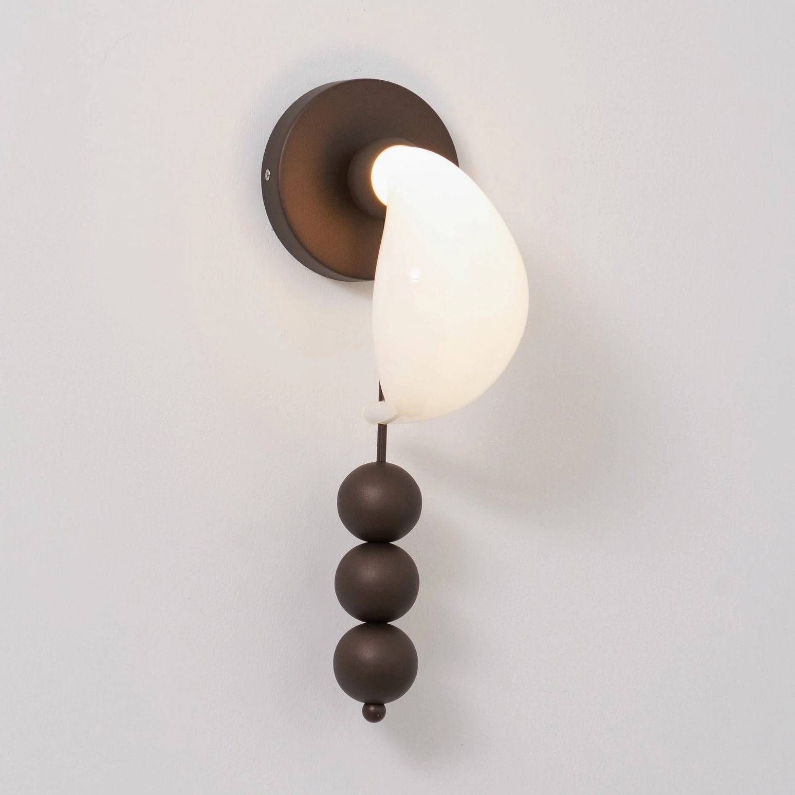 Contemporary wall sconce with sculptural spheres and curved glass shade, statement lighting piece for modern interiors