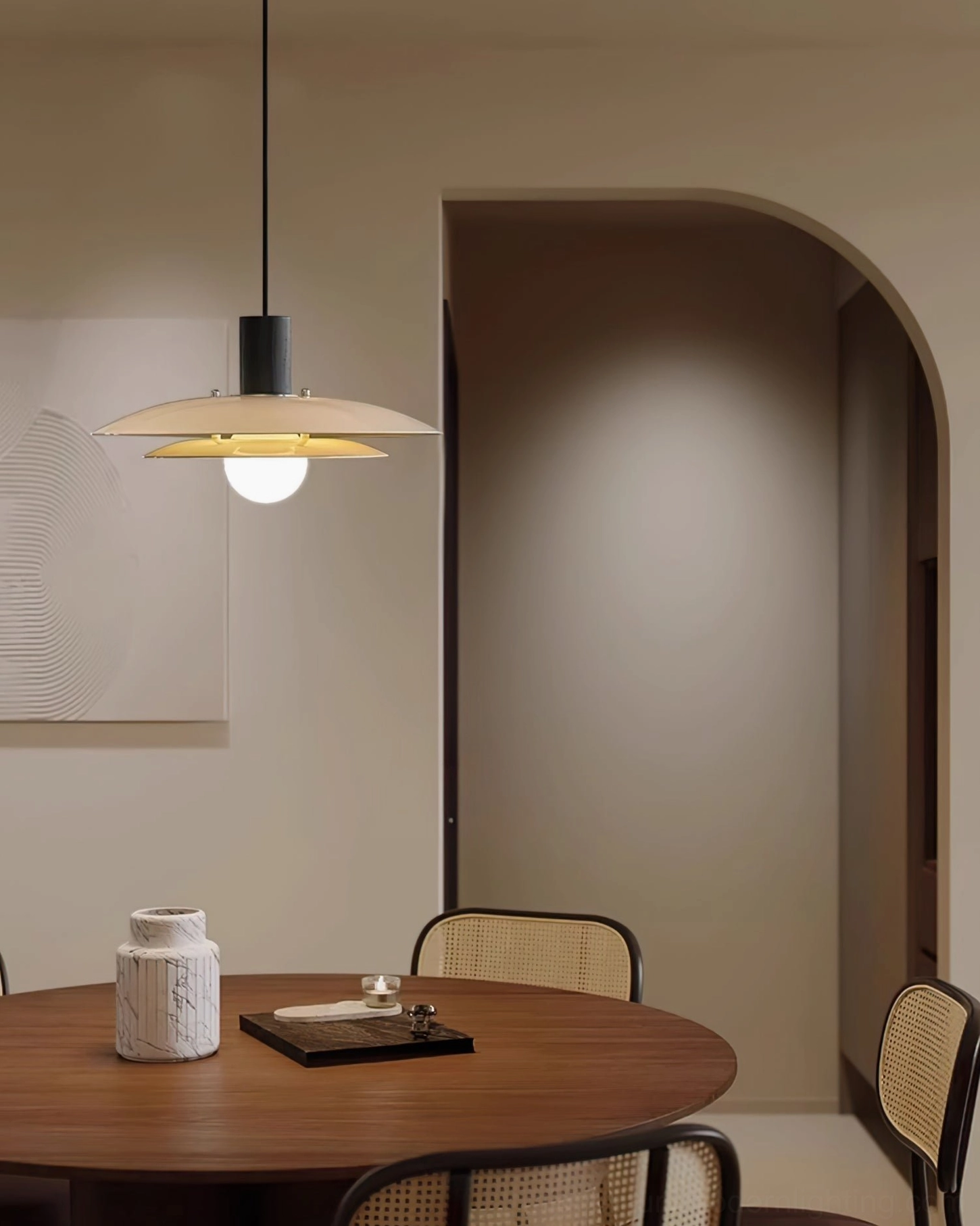 Contemporary wood pendant light creating warm ambiance above small wooden round dining table in minimalist interior