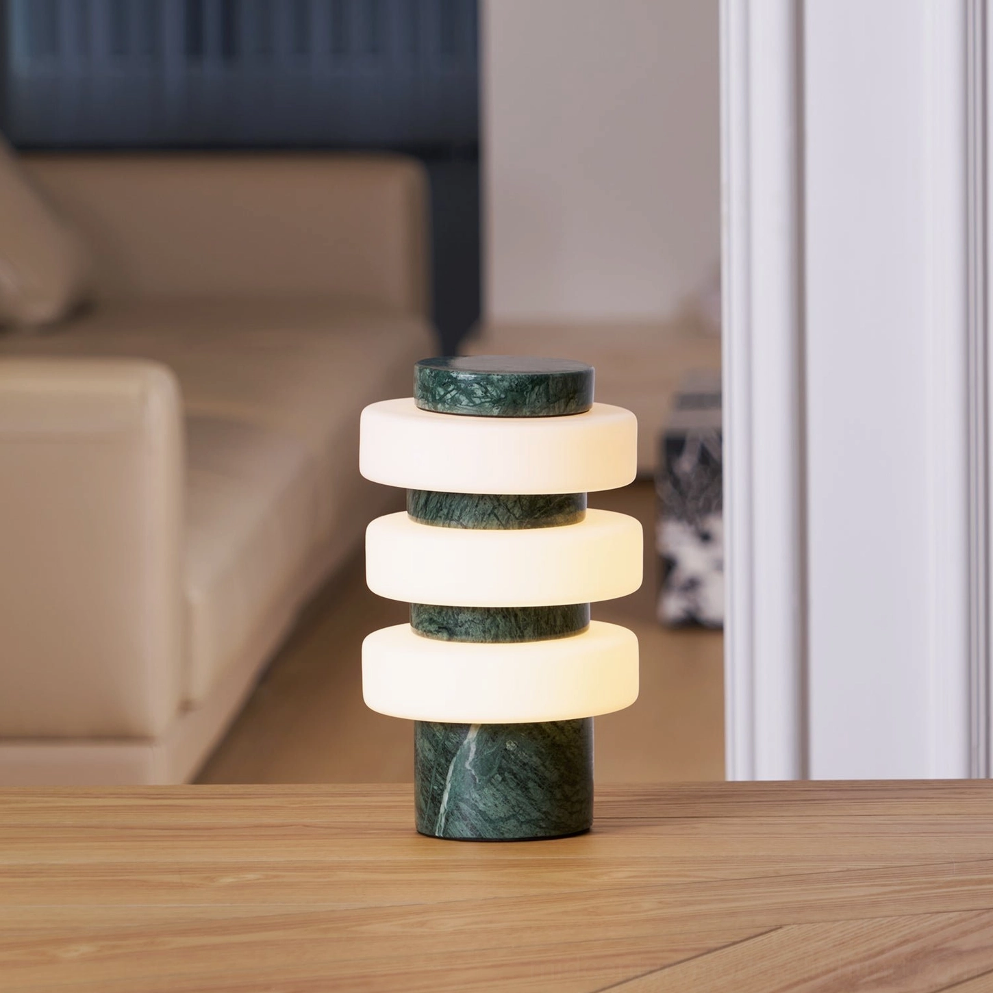 Corba green marble table lamp with illuminated frosted glass rings on bedroom wooden bedside table