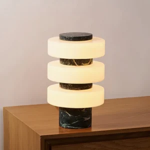 Corba stacked glass table lamp with green marble base glowing on wooden side table, mid-century modern design