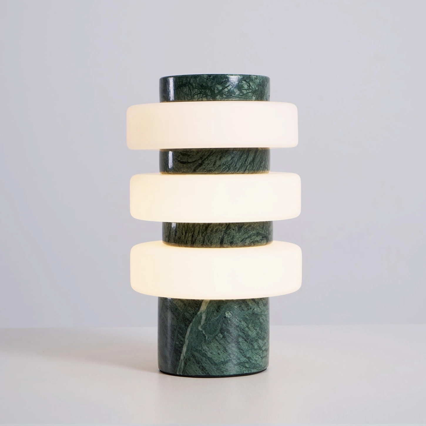Corba table lamp with travertine stone base warm frosted glass rings minimalist aesthetic