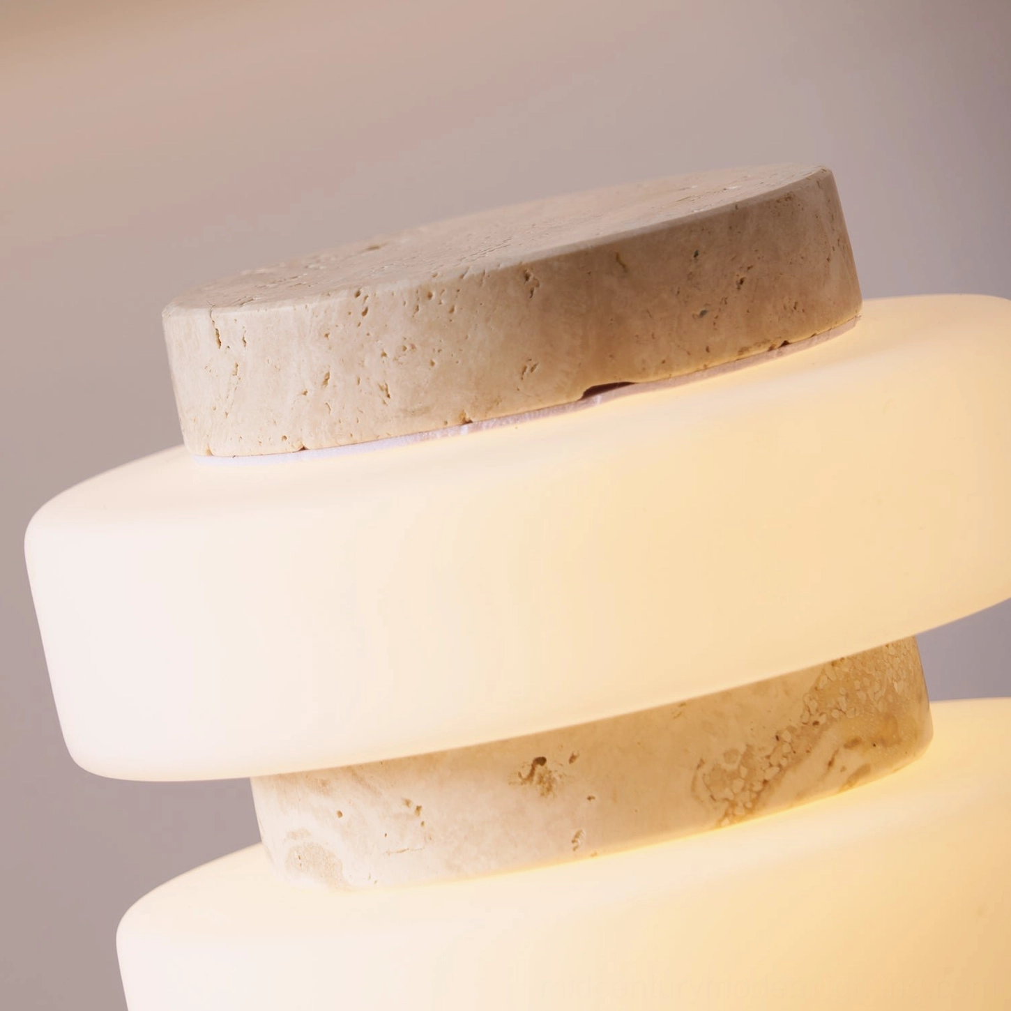 Macro detail of Corba lamp travertine stone texture and frosted glass disc layering