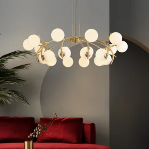 Corbett handcrafted brass chandelier installed in luxury living room with red velvet sofa, low angle view