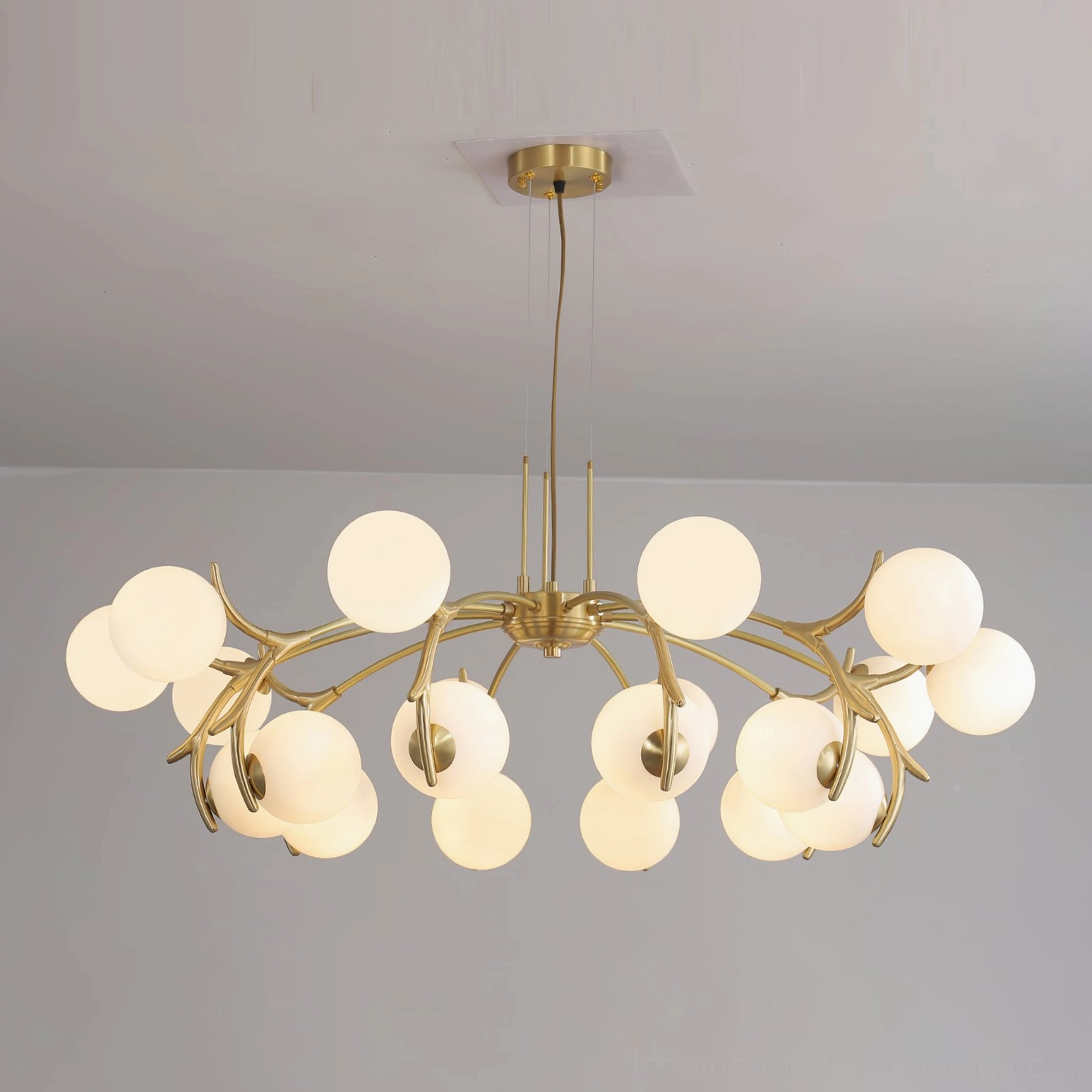 Corbett gold chandelier illuminated in elegant interior setting, warm ambient lighting