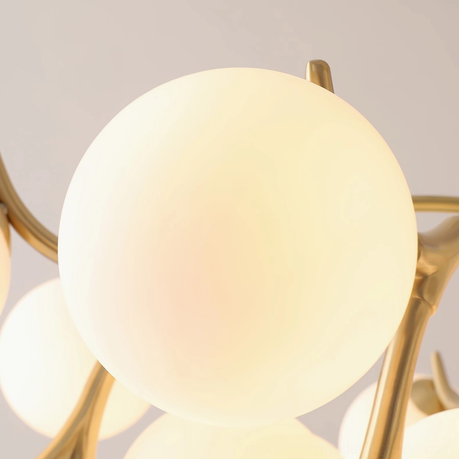 Corbett modern brass globe chandelier in minimalist white room, contemporary overhead lighting