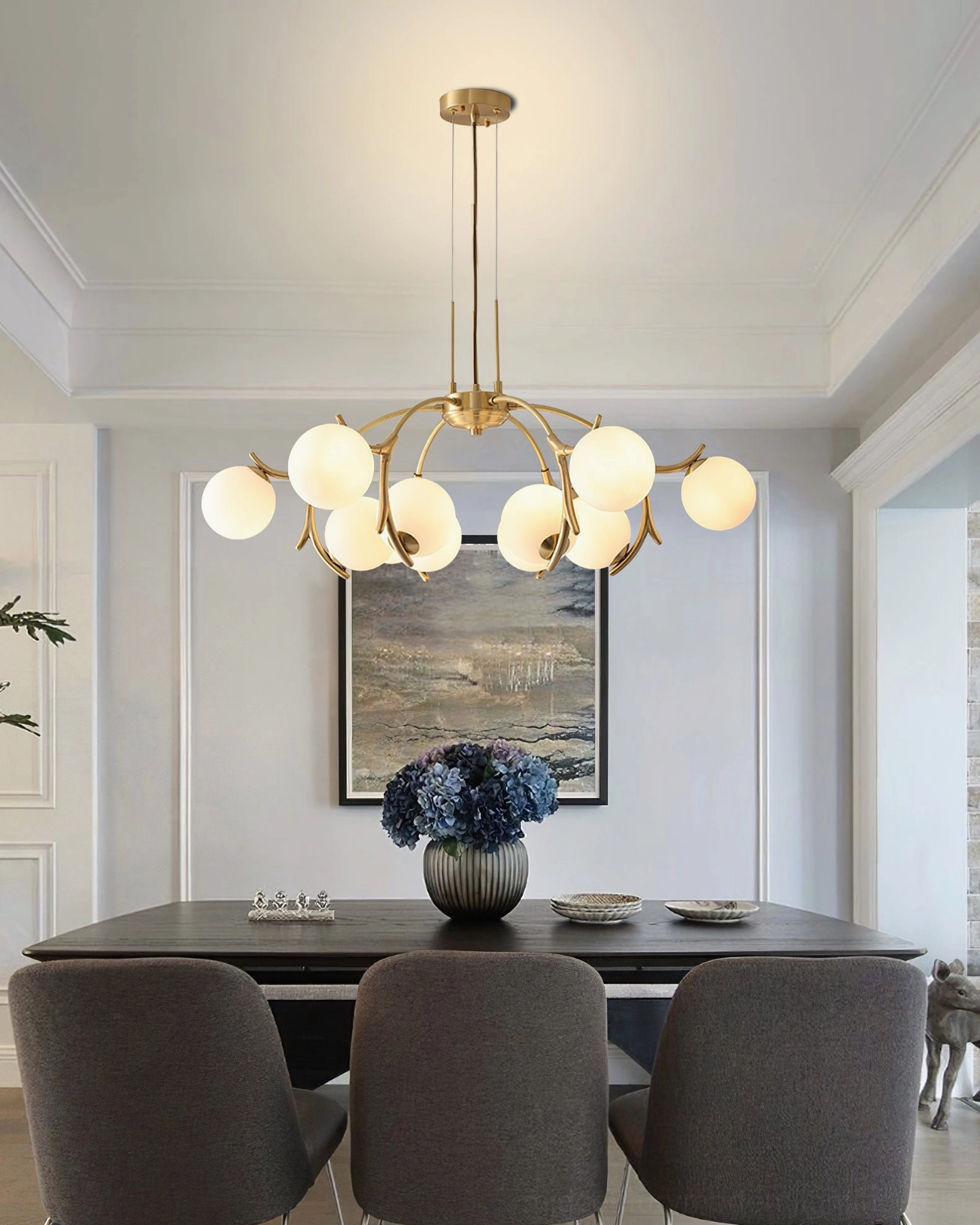 Large 20-head Corbett brass chandelier in living room with floor-to-ceiling ocean windows