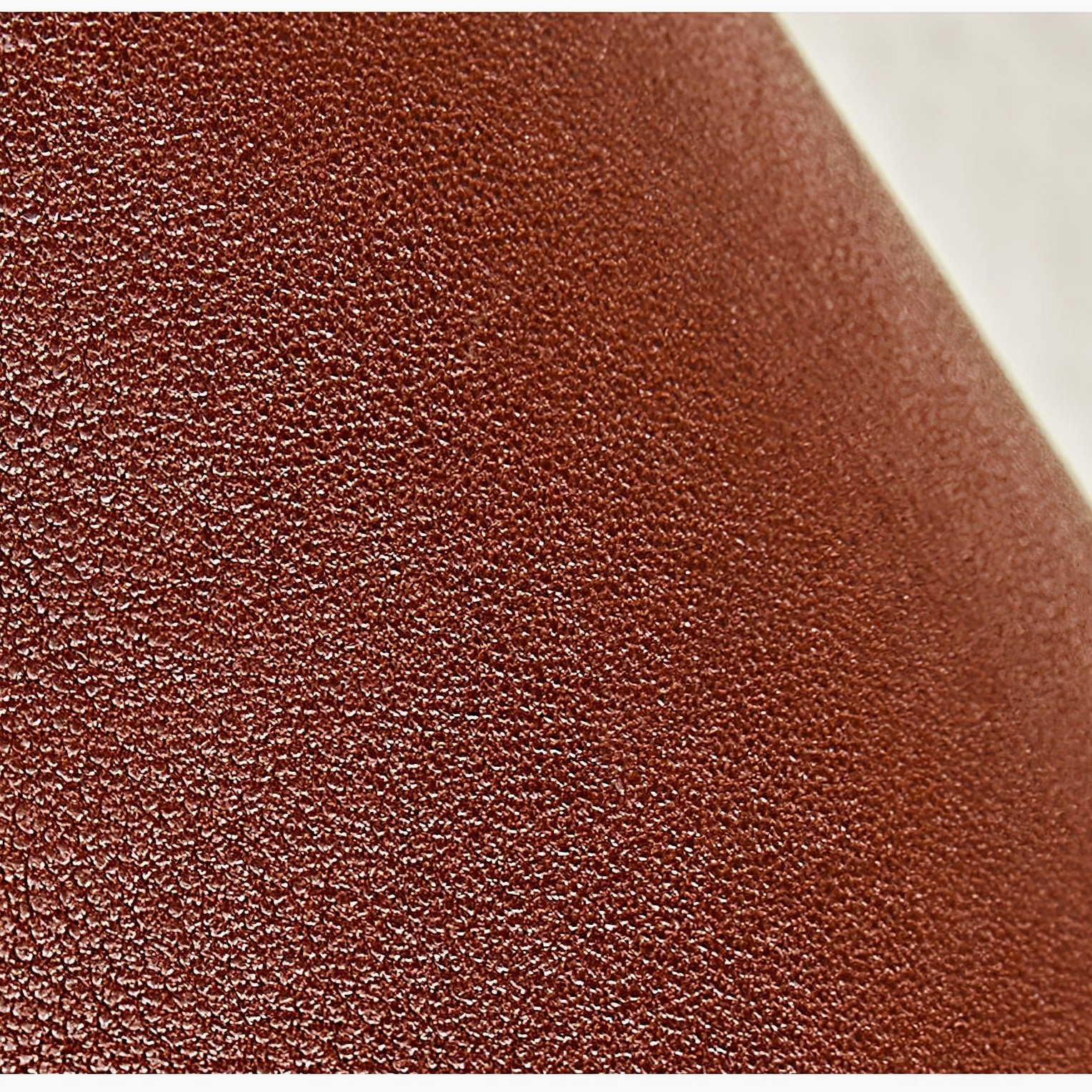 Close-up detail of Cordoba sconce leather material showing fine grain texture and matte brown finish