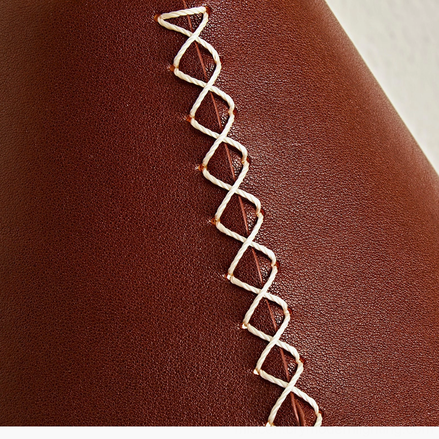 Hand-stitched leather shade detail on Cordoba sconce showing white crisscross stitching craftsmanship