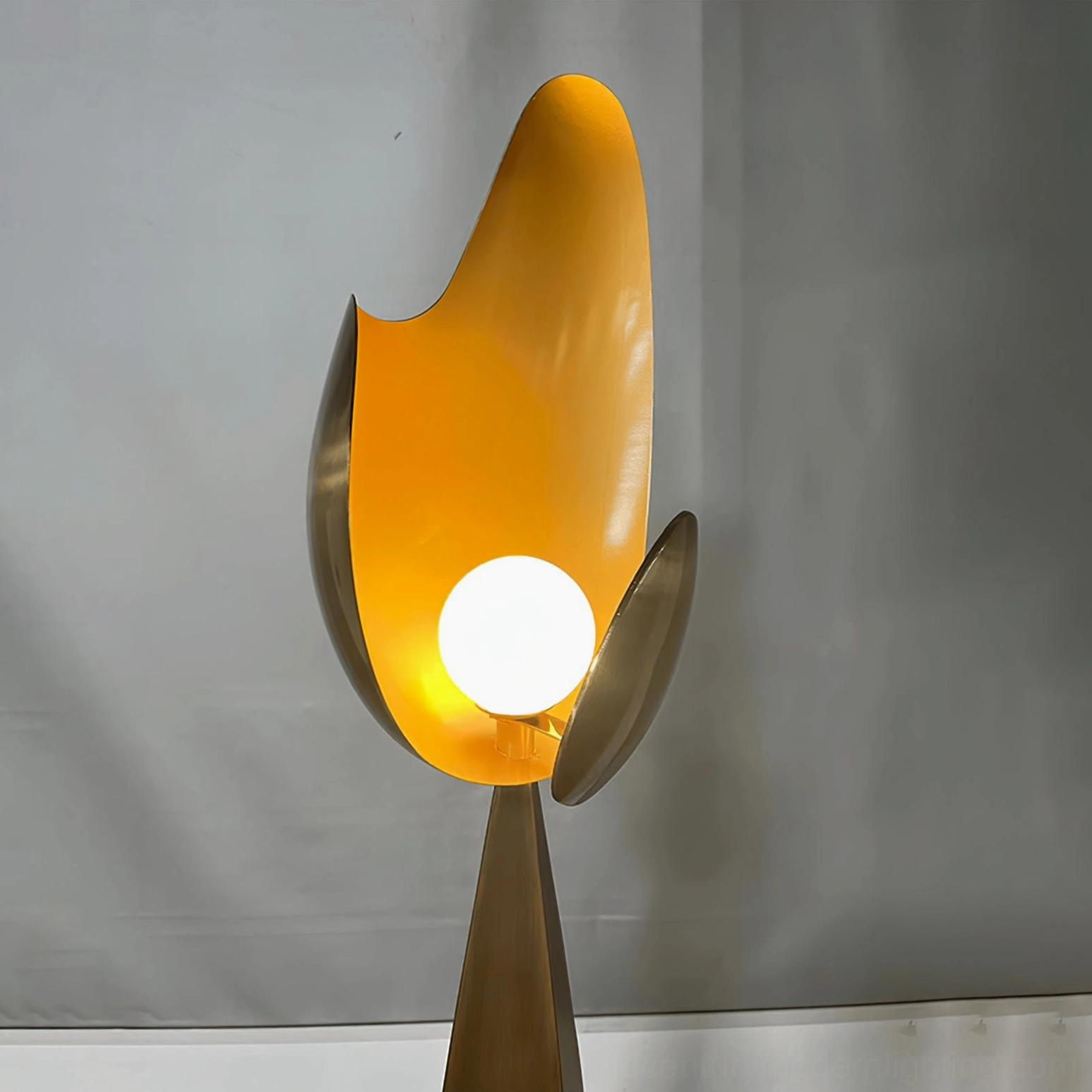 Cosmo floor lamp close-up showing exposed round globe LED bulb with amber warm light, dual curved metal shade