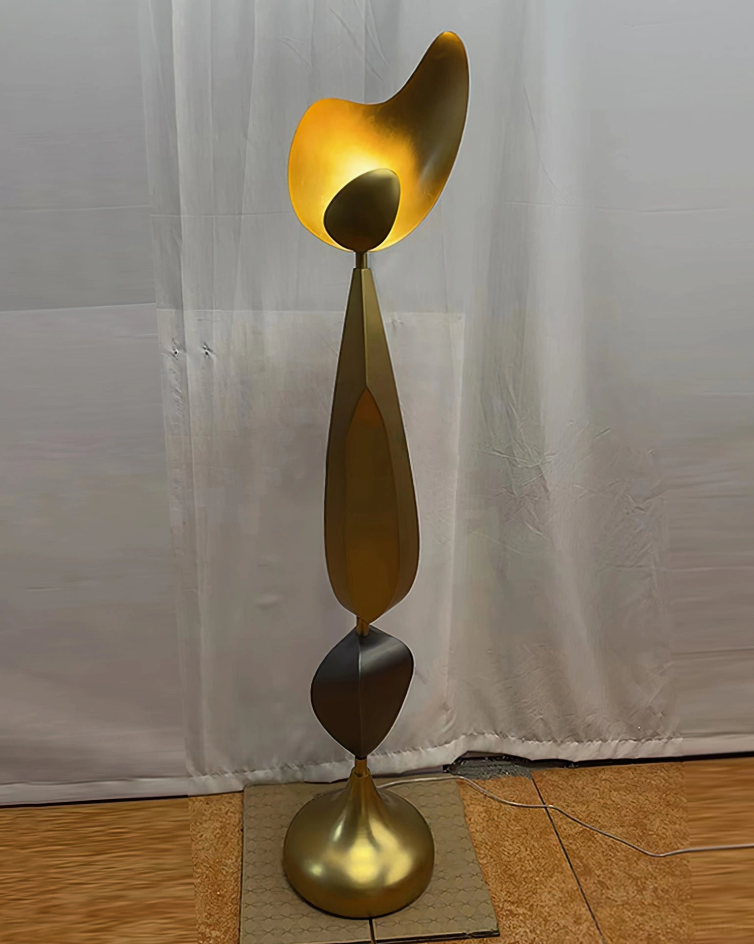 Illuminated Cosmo floor lamp with warm glowing bronze shade, home interior setting with wood flooring