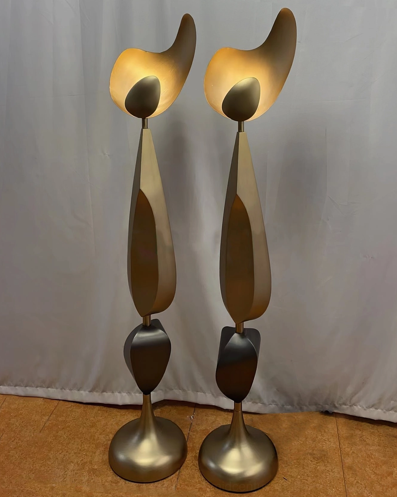 Matching pair of Cosmo floor lamps with uniform bronze-black design in contemporary home with wood flooring