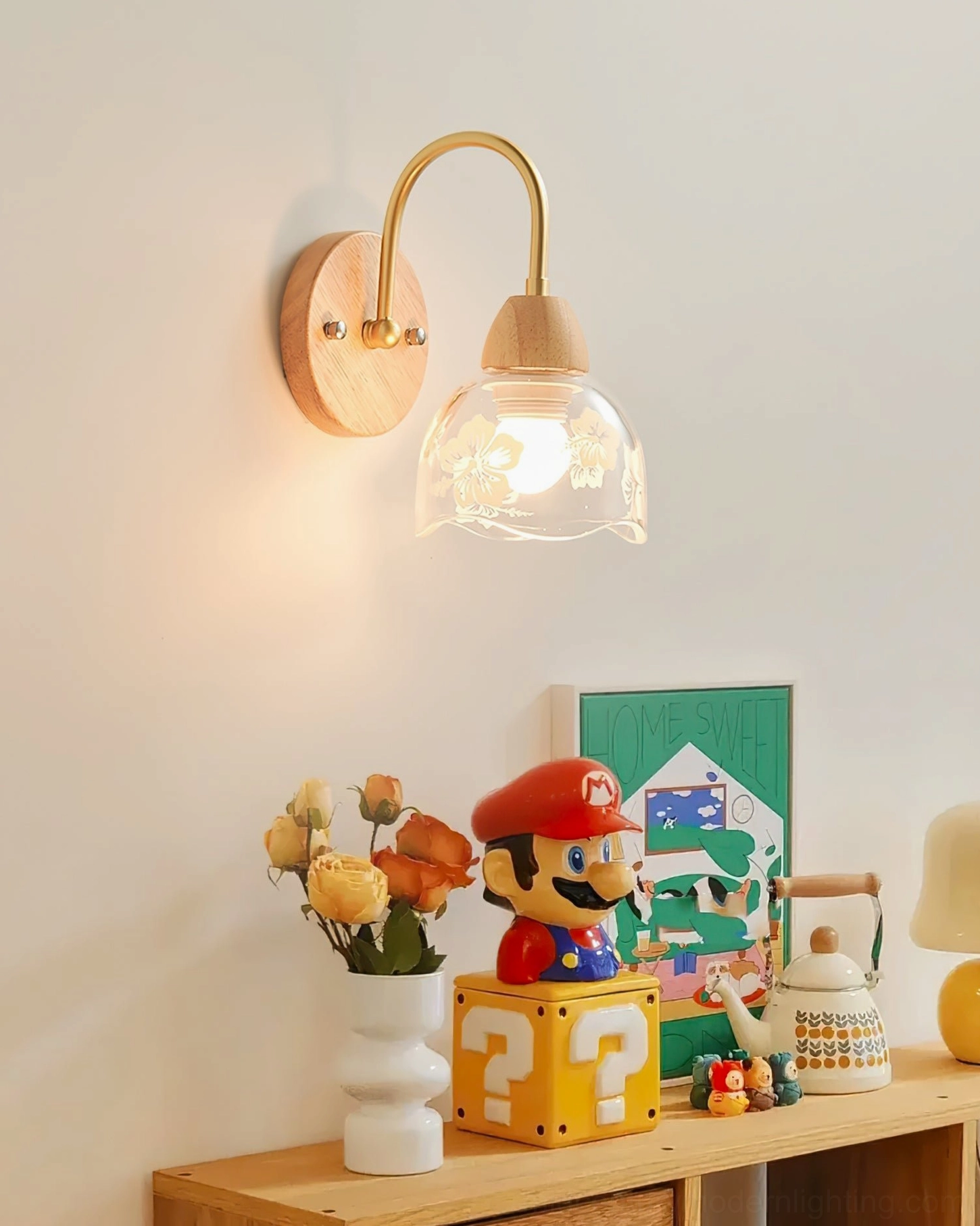 Armed wall sconce mounted above workspace with playful minimal decor arrangement