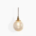 Crackle glass globe pendant light with brass fitting, front view showing textured clear glass and warm LED bulb illumination