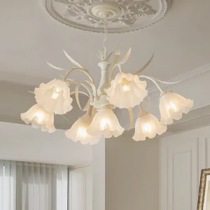 Overhead view of cream pendant chandelier installed in French style living room with ornate ceiling medallion, warm ambient lighting