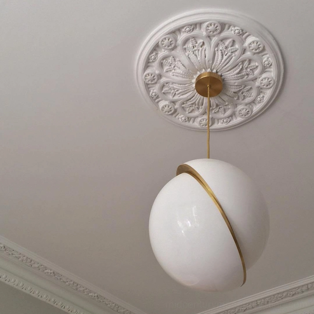 Single crescent pendant lamp mounted on neoclassical carved ceiling rose