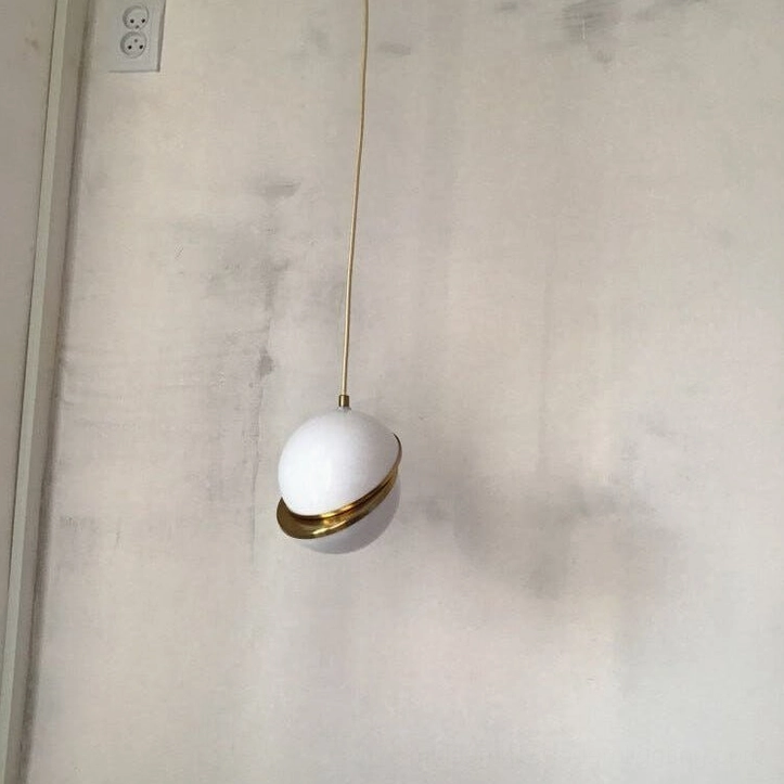 White opal crescent pendant light with brushed gold fascia minimal contemporary aesthetic