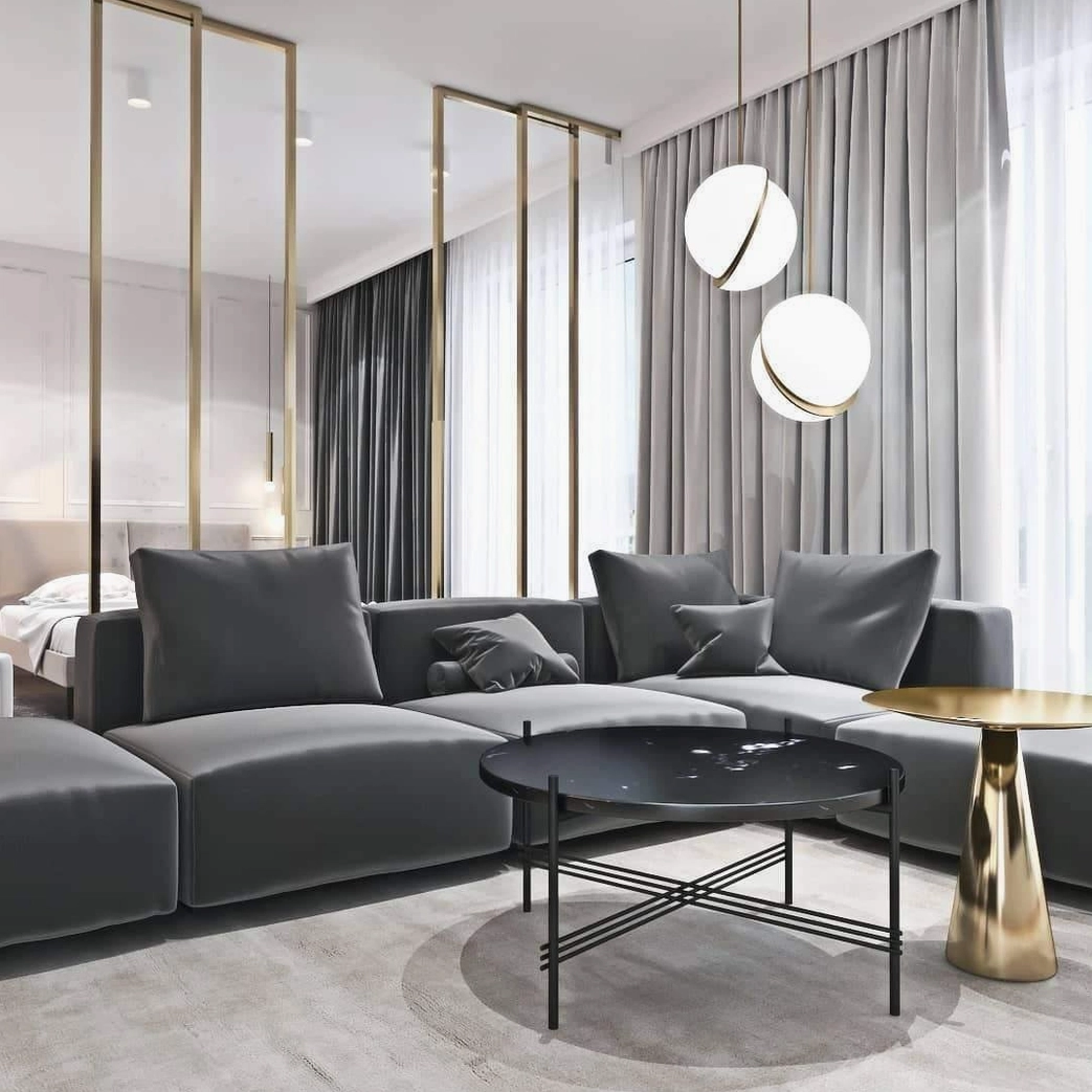 Pair of crescent pendant lights in modern open-plan living room with grey sofa and floor curtains