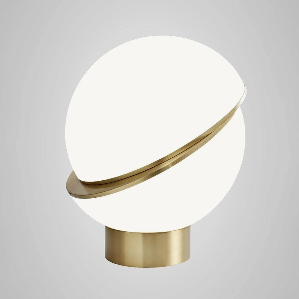 Low angle front view of Crescent Sphere Table Light showing angled brass decorative ring around frosted globe