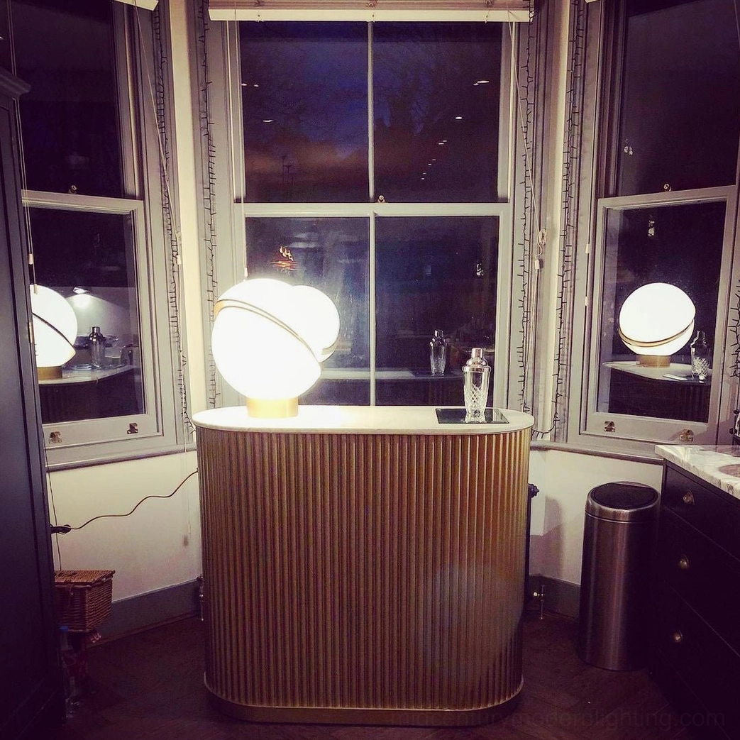 Crescent Table Light creating warm ambient lighting on kitchen counter by window during evening