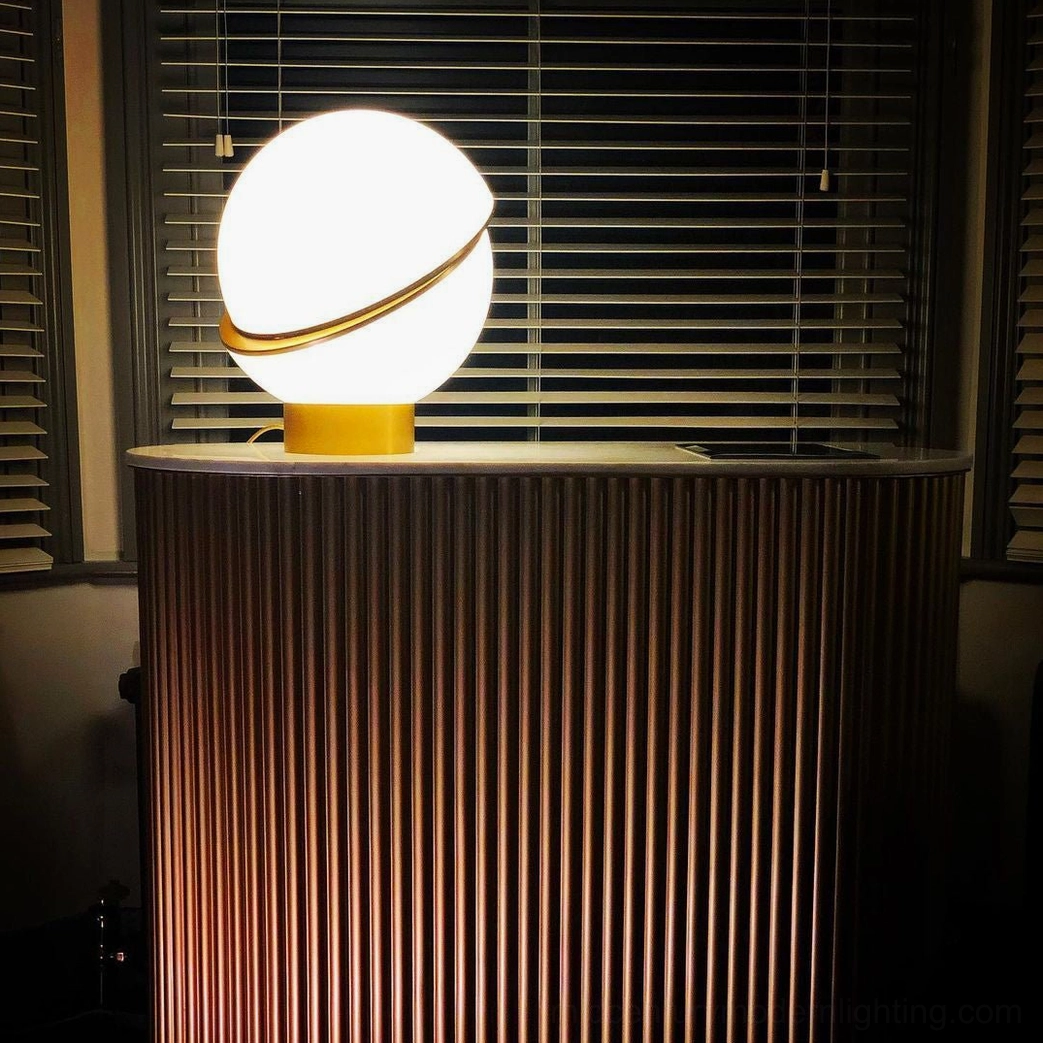 Crescent Table Light side profile view in luxury home corner with window blinds and fluted cabinet storage