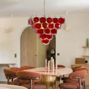 Stiletto Crimson Disc Chandelier installed in modern dining room with round table and warm neutral interior decor