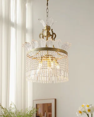 Brass crinoline chandelier illuminated in cozy living room with sheer curtains and greenery