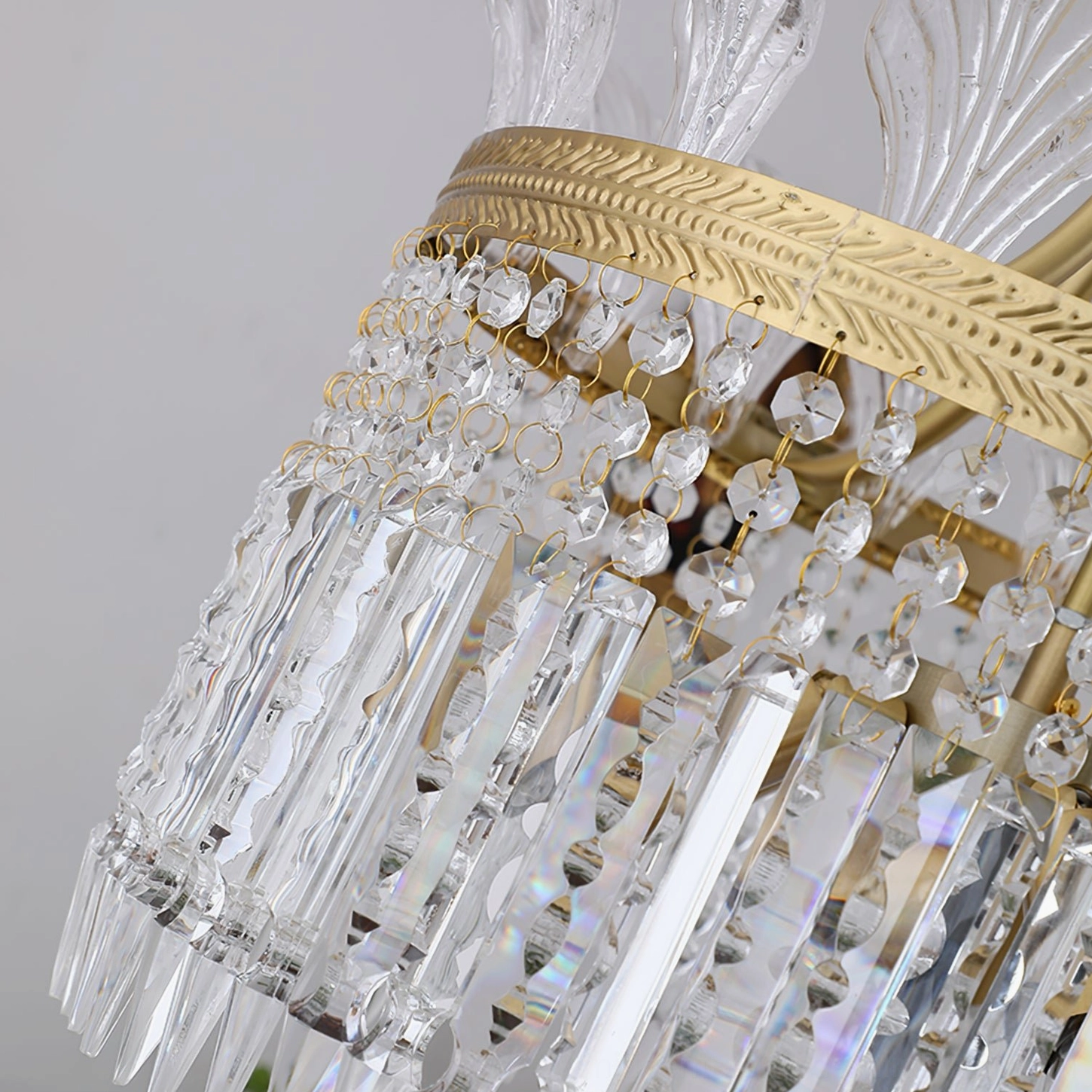 Tiered brass and glass crinoline chandelier with petal-shaped finial close-up