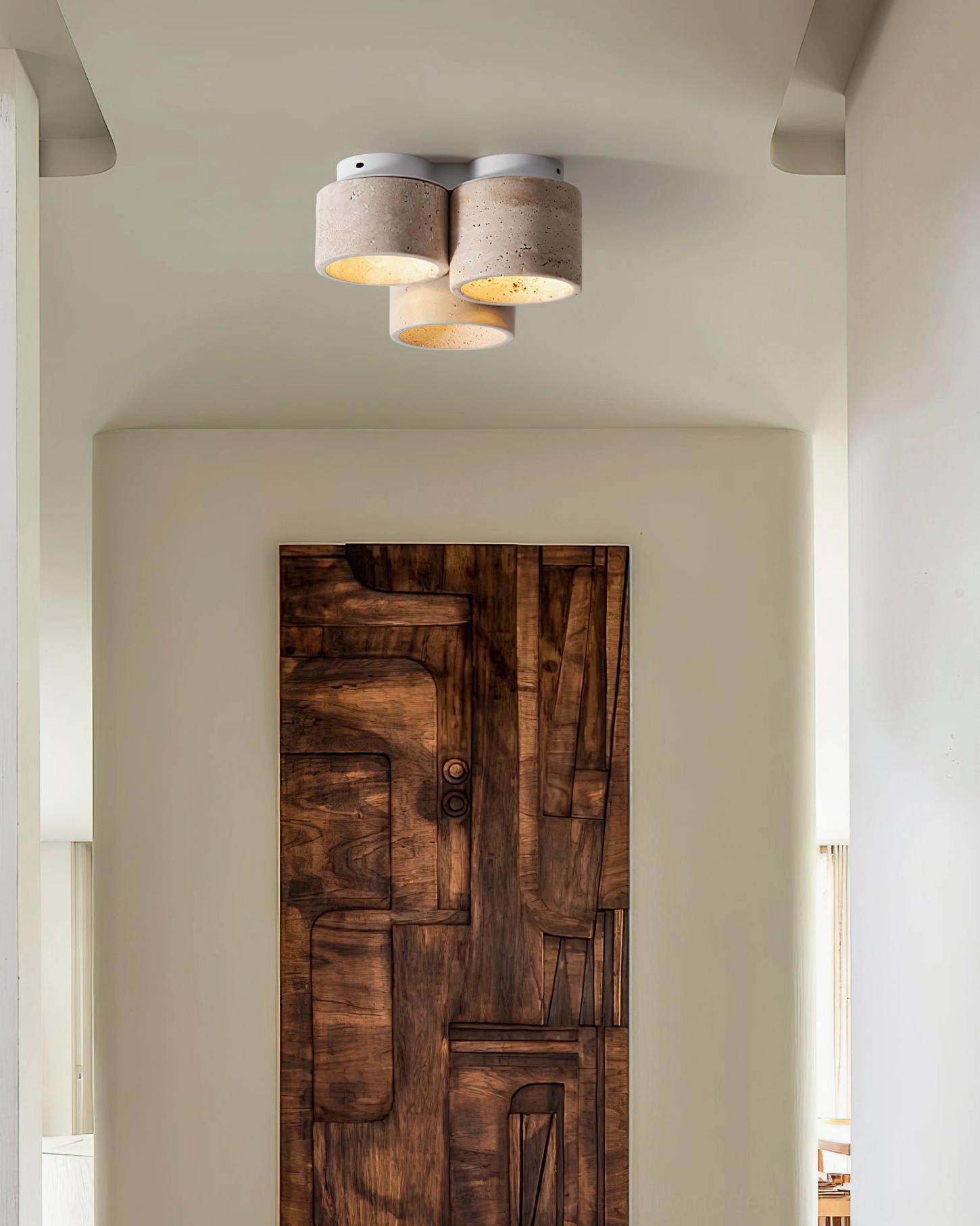 Cromia travertine ceiling light mounted in residential hallway above wooden door, warm wood tones creating cohesive interior