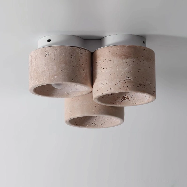 Bottom view of Cromia three-cylinder travertine ceiling light on white background showing natural stone detail and white metal base