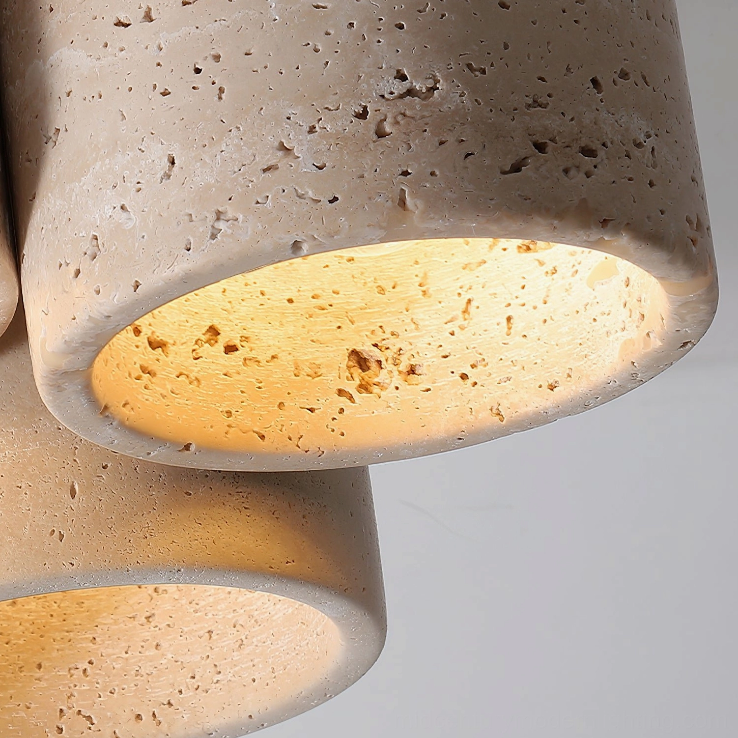 Cromia travertine three-light fixture color options in beige and walnut finish with warm glowing illumination