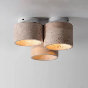 Close-up detailed view of Cromia travertine ceiling light highlighting rough natural stone texture with warm internal illumination
