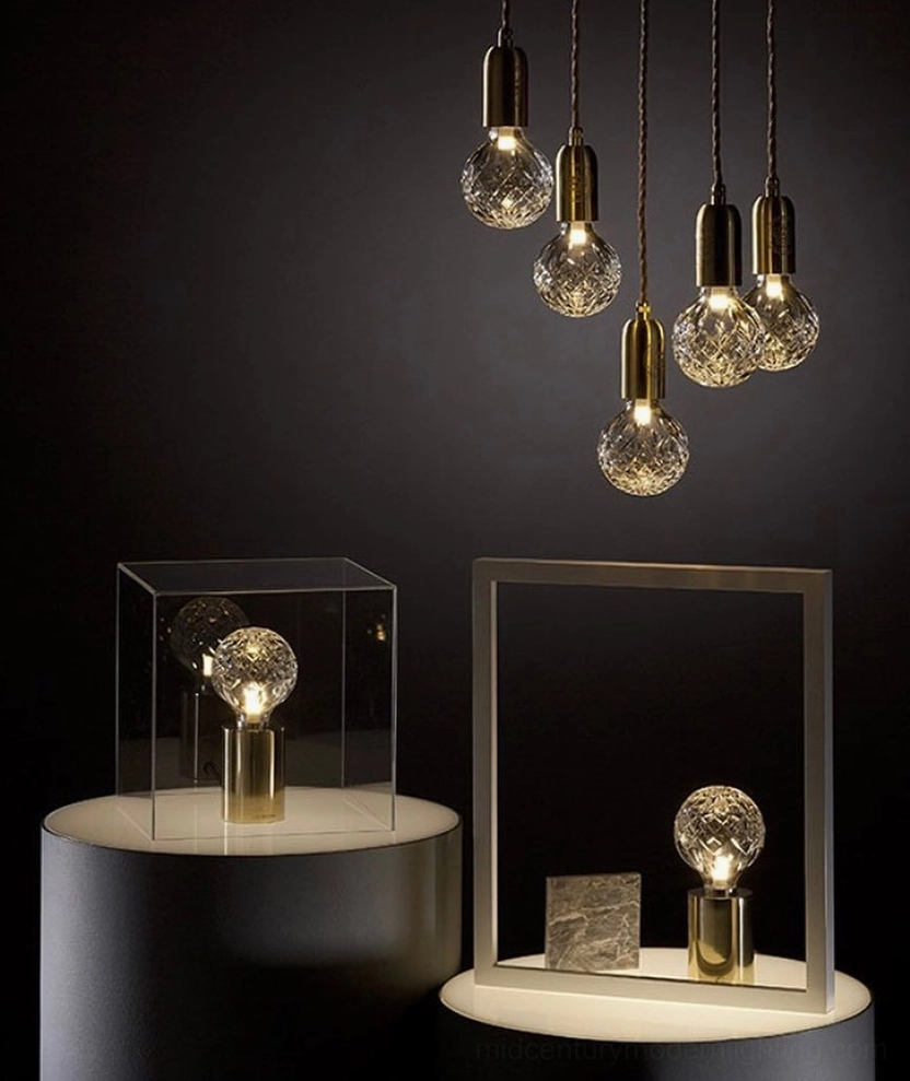 Crystal bulb pendant and table lamps collection with hand-cut faceted glass on display stand