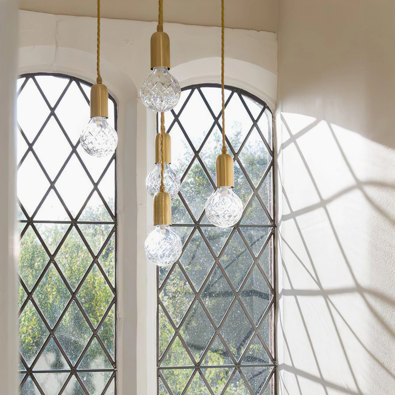Single crystal pendant light in vintage entryway with brass hardware and leadlight window