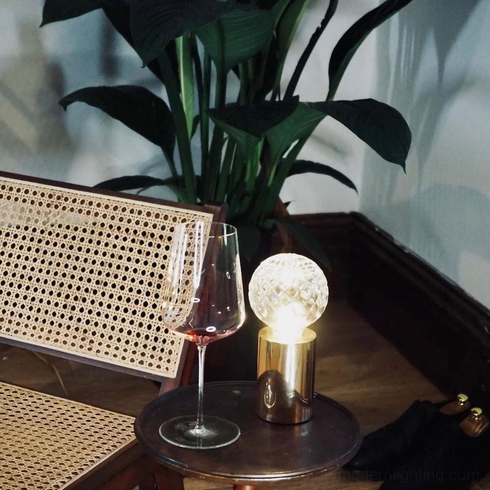 Mid-century modern crystal bulb table lamp on lounge side table with wine glass and green plants