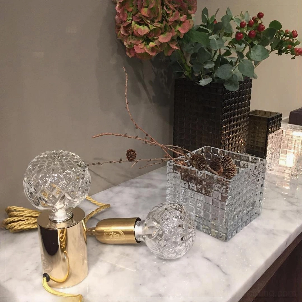 Hand-cut crystal bulb table lamp close-up showing precision faceting and light refraction