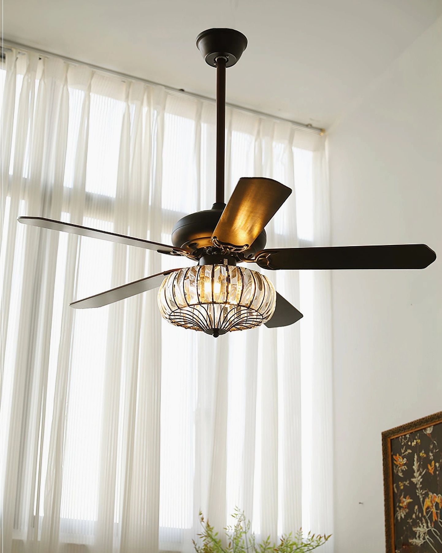 Crystal cage ceiling fan light with integrated LED, 5 blades, black-bronze finish, low angle view with sheer curtain backdrop