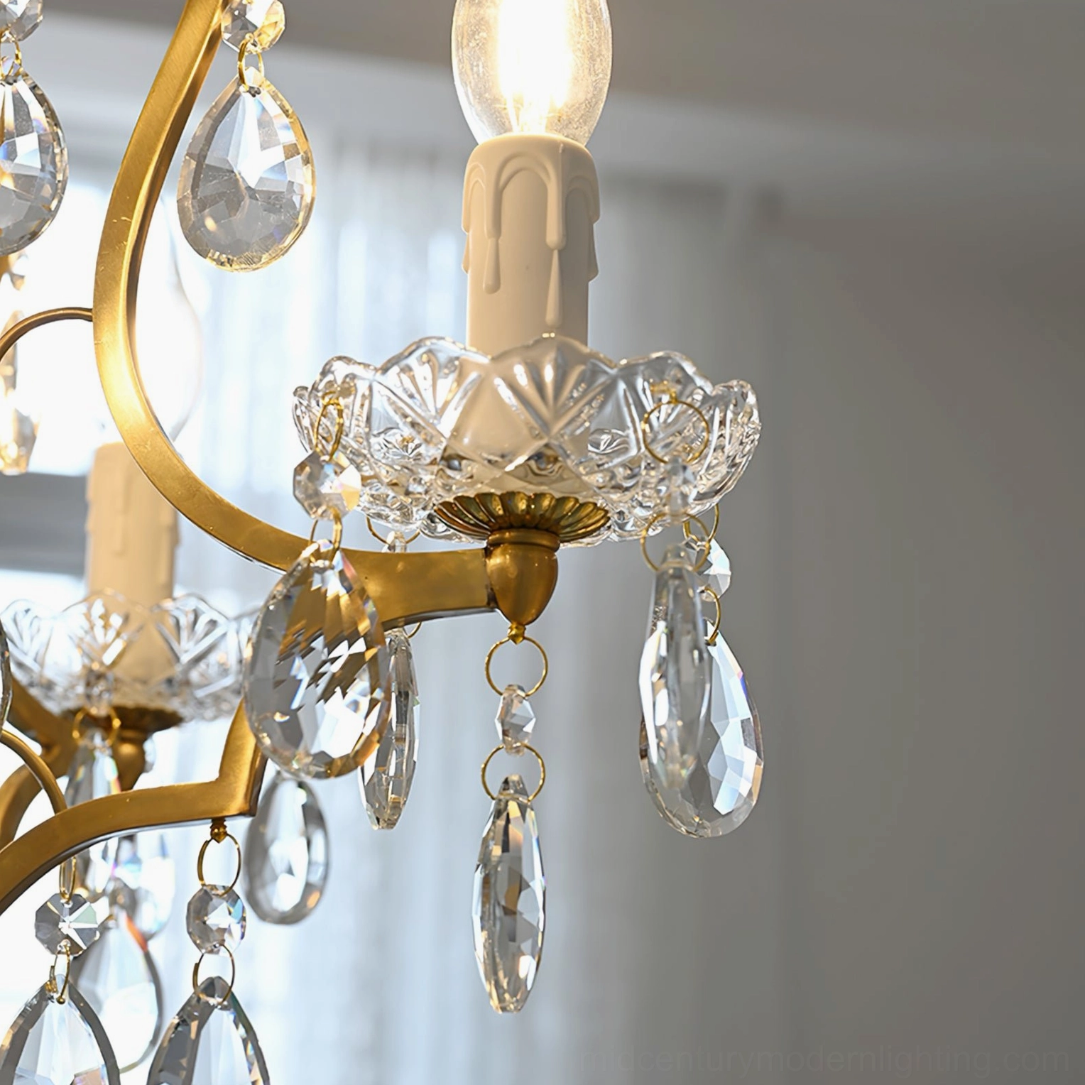 Close-up detail of crystal chandelier's embossed glass candle cup and faceted crystal pendants