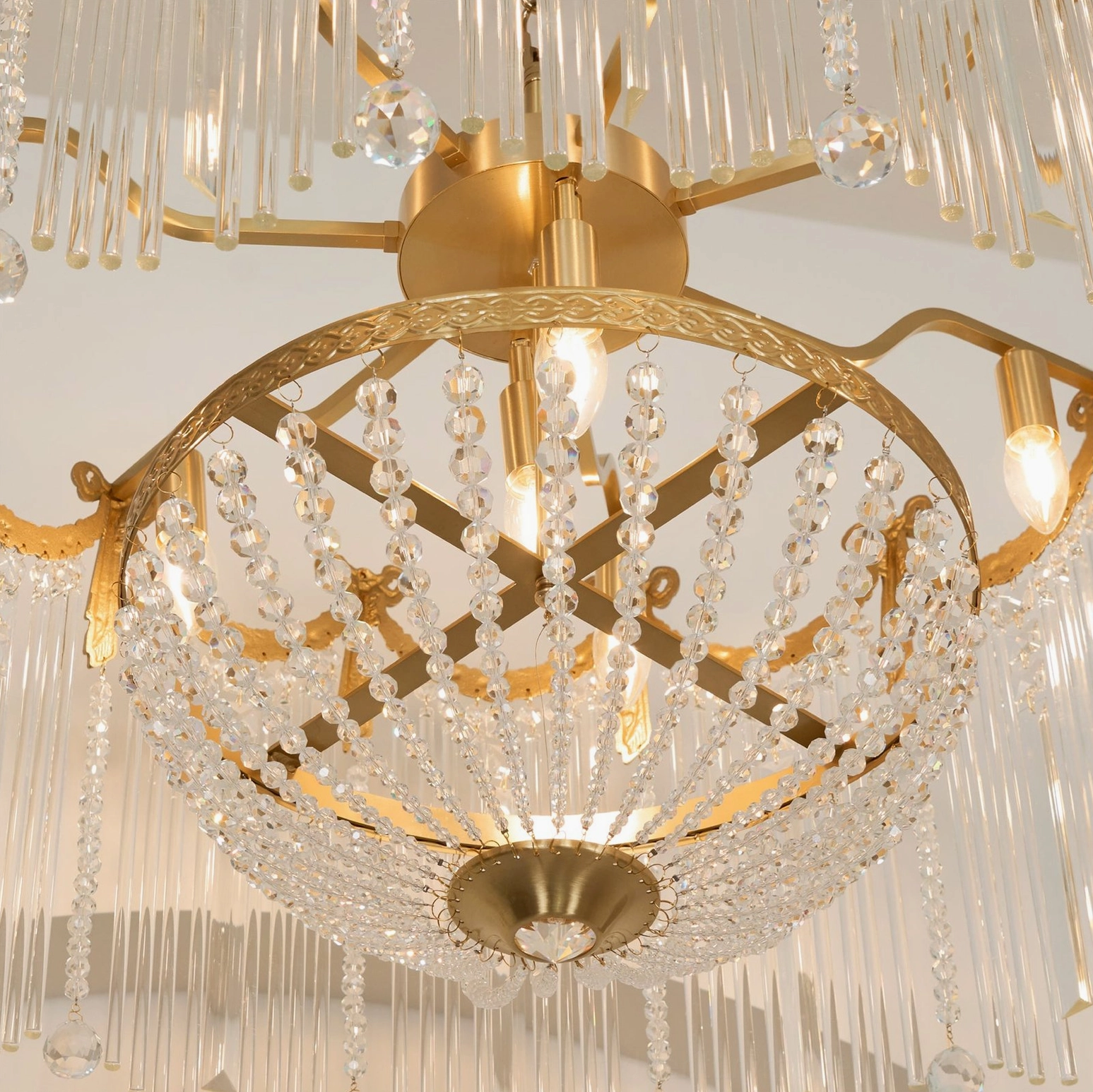 Close-up frontal view of layered crystal pendants and cross brass frame with illuminated bulbs