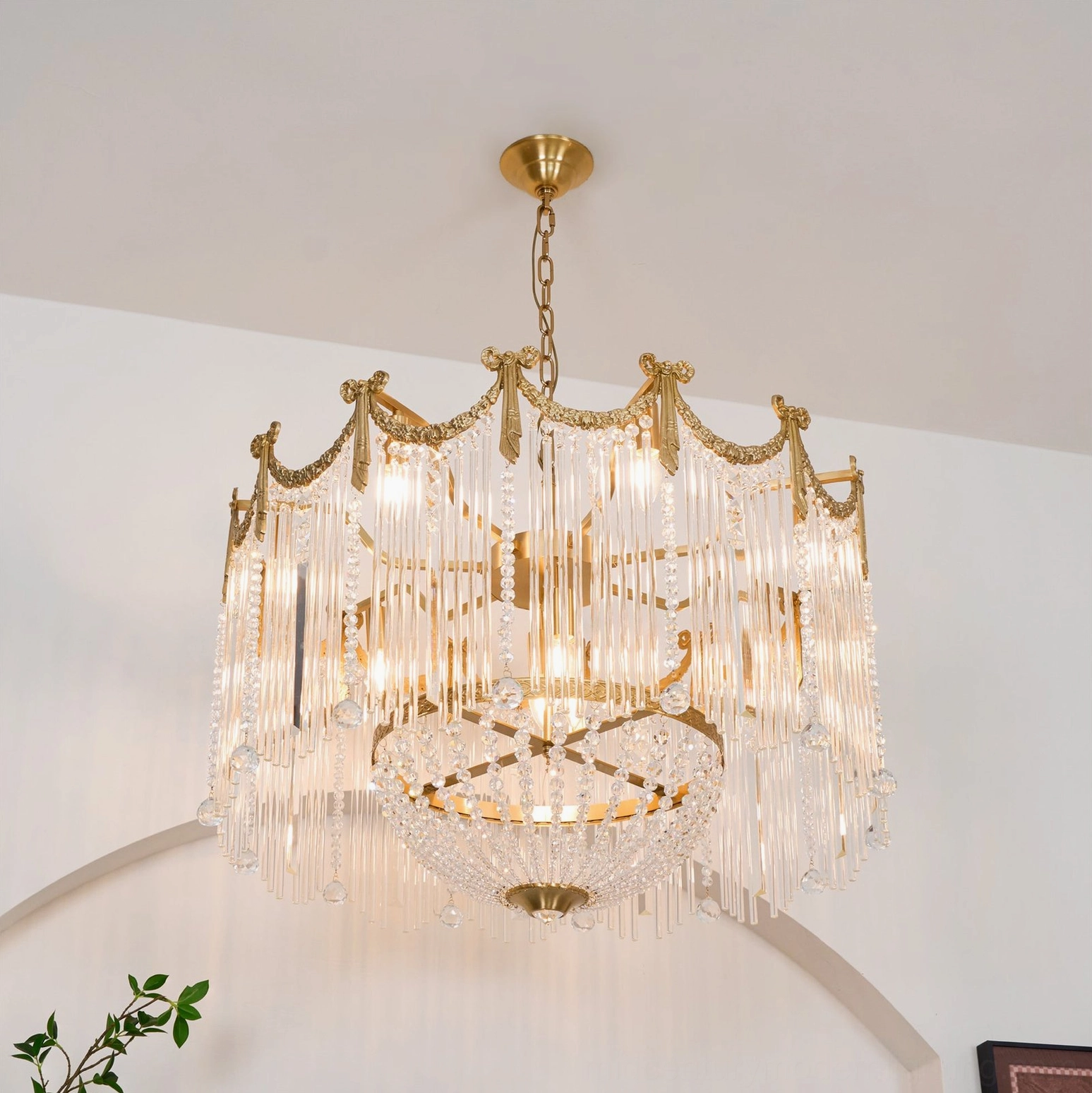 Fully illuminated crystal teardrop chandelier with dense glass tassels and elegant crown frame indoors