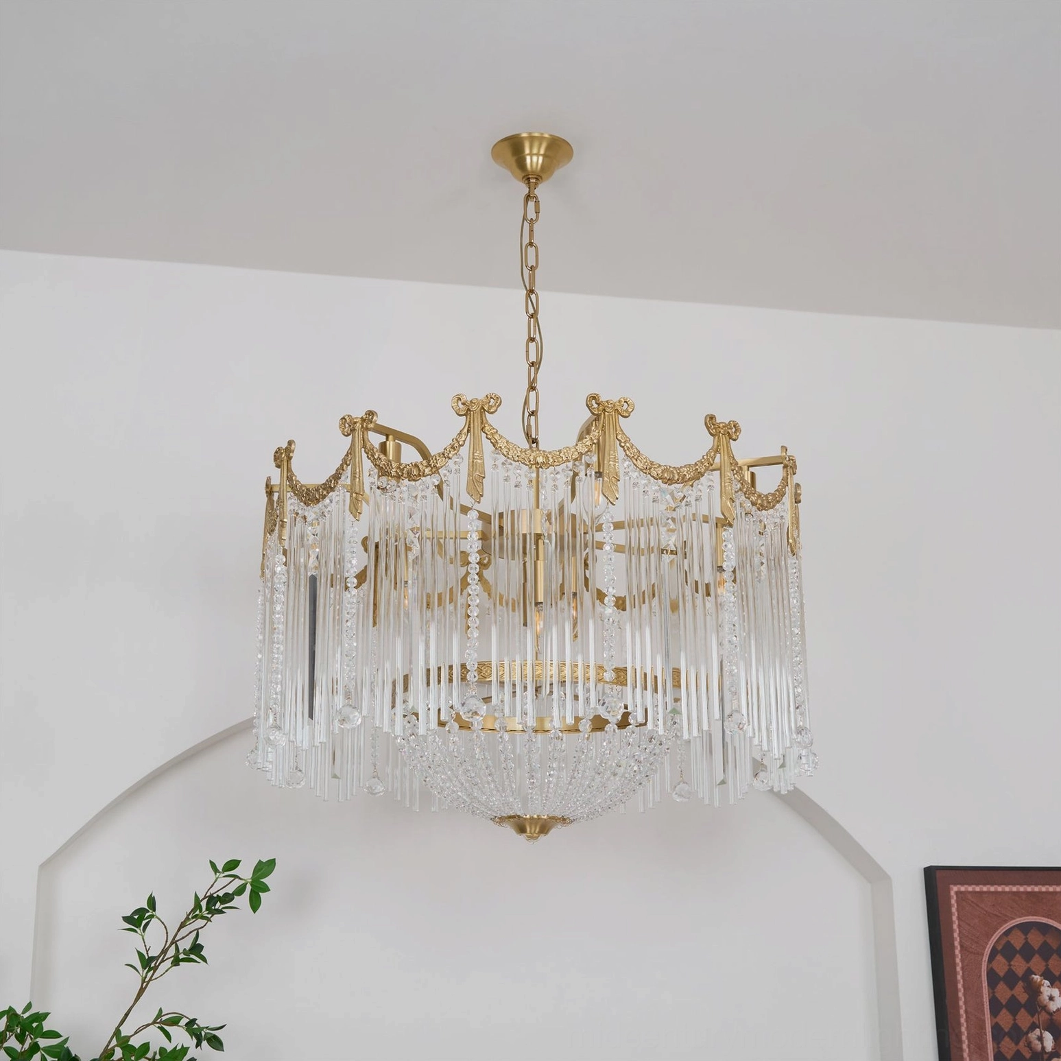 Side profile of crystal chandelier showing layered glass tassel trim and gold chain suspension detail