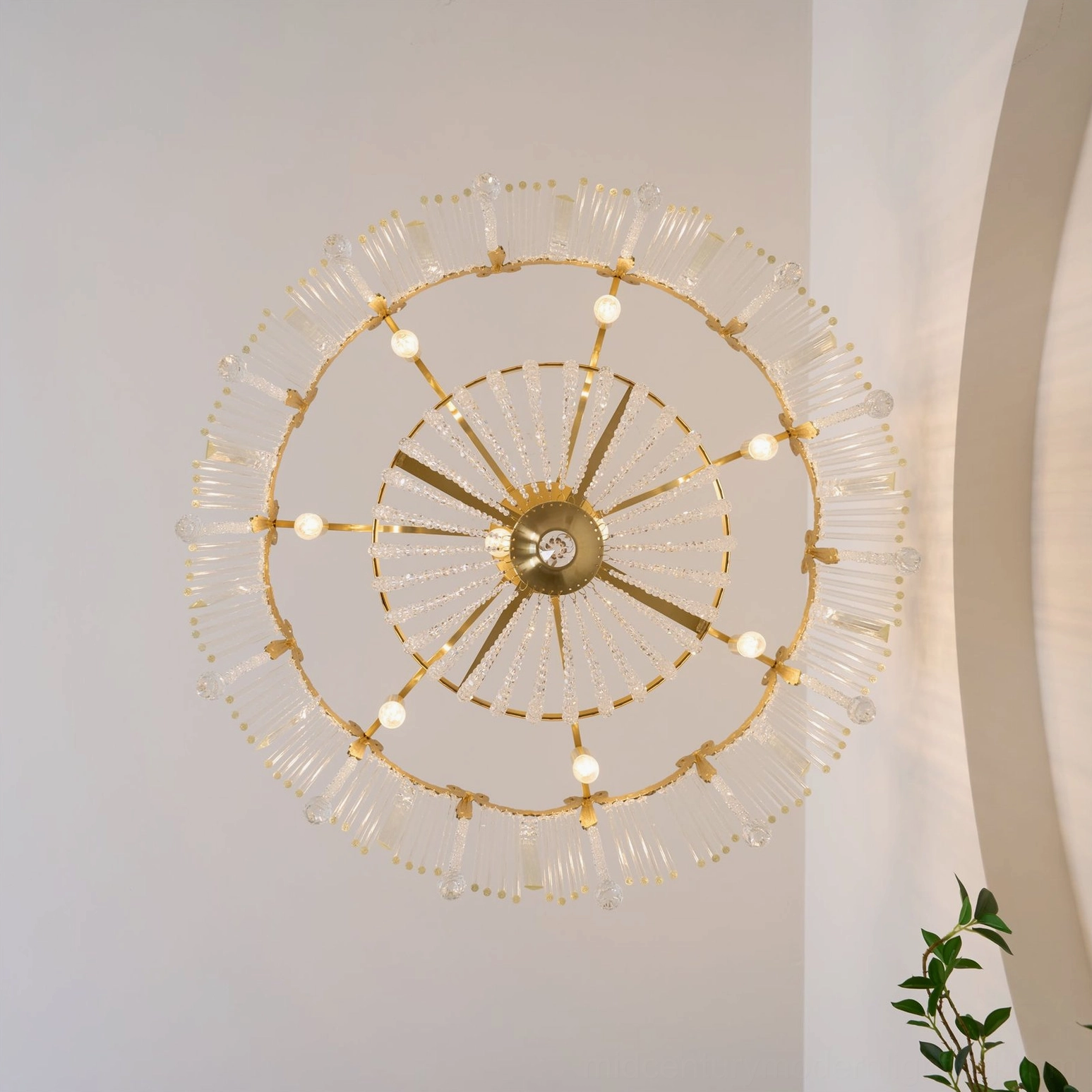 Overhead top-down view of crystal chandelier showing radial brass metal structure and central crystal ornament